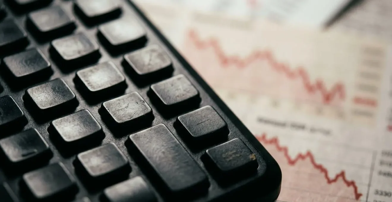 Vista macro de calculadora financiera y gráficos de tendencia descendente en papel